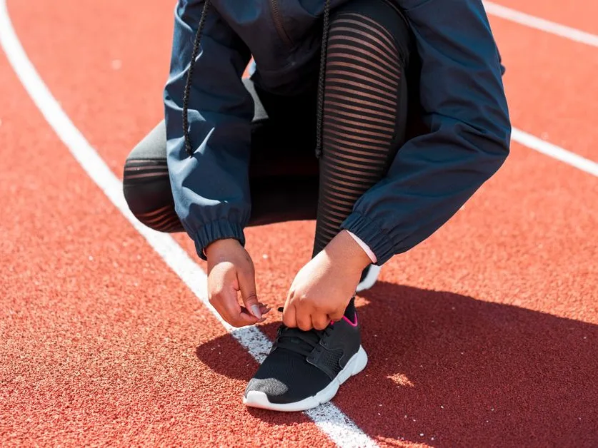 Sportif qui lace ses chaussures de course sur une piste avant la séance